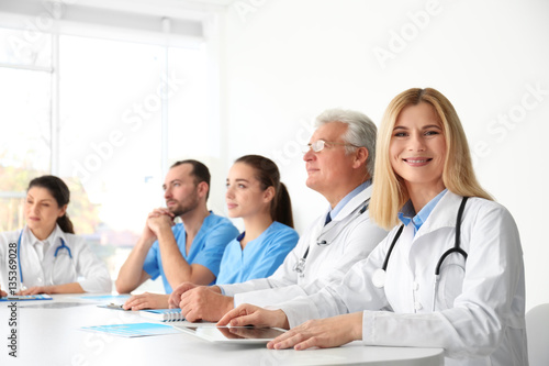 Team of doctors sitting at table in clinic