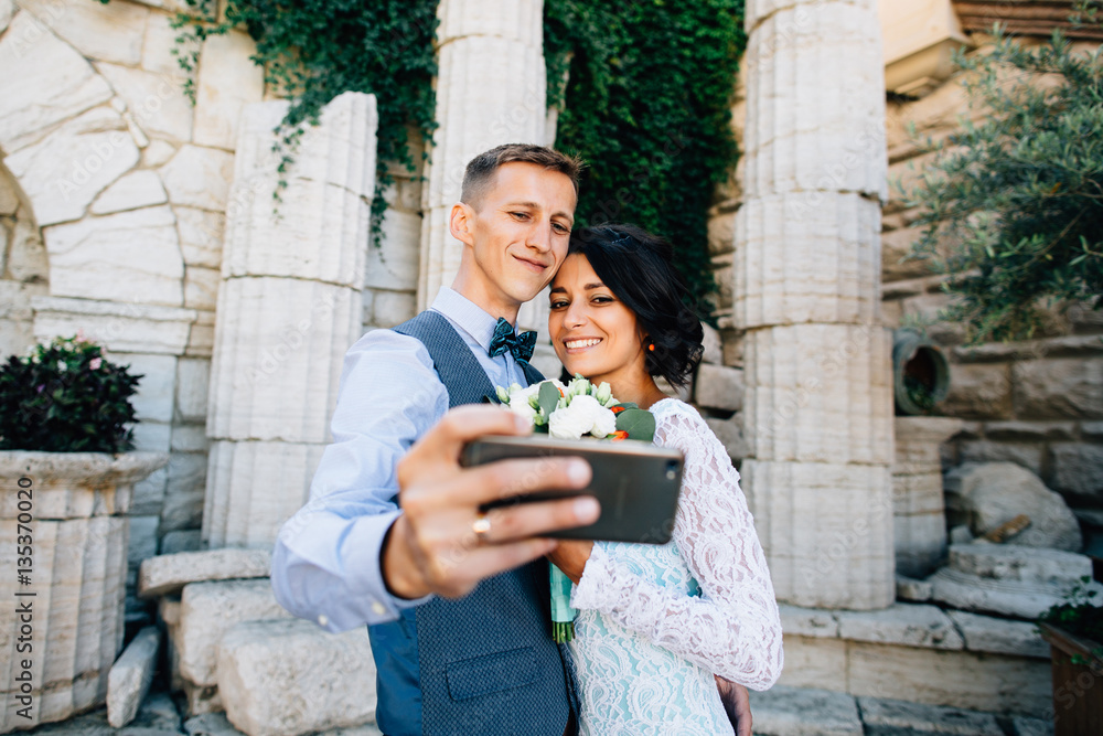 Wedding travel selfie. Groom and bride takes selfie on mobile phone in Greece