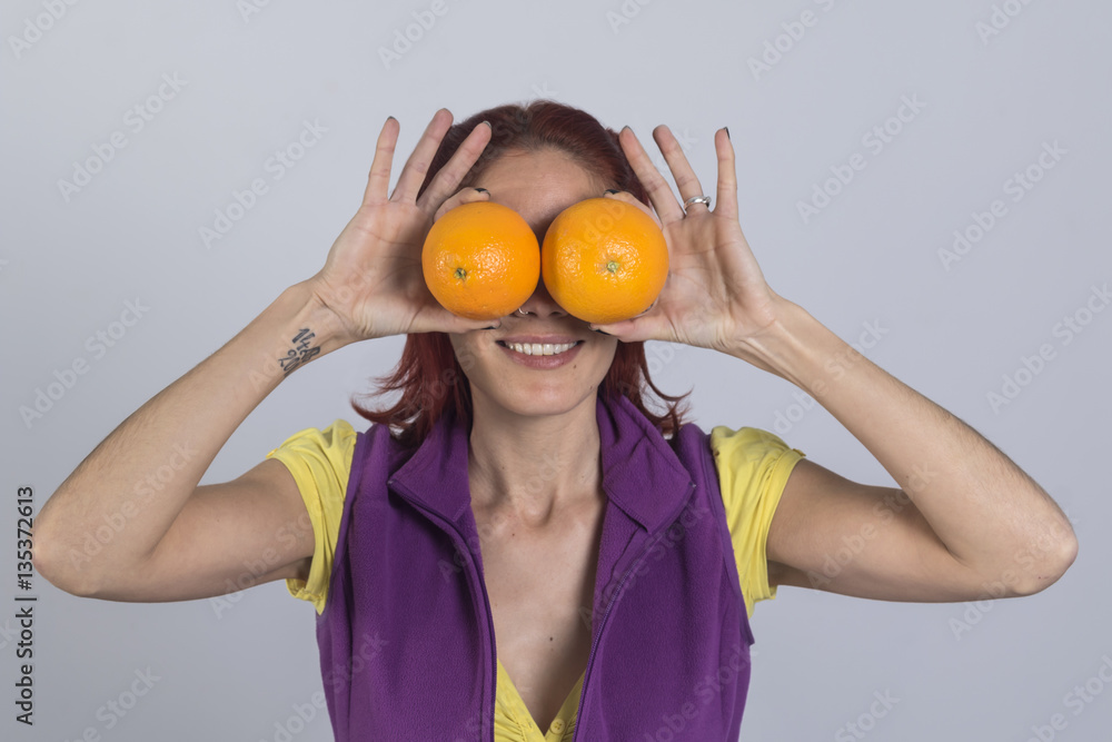 Mujer que cubre los ojos con naranja. Mujer que cubre los ojos con naranja.