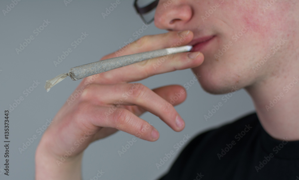 Obraz premium Mann hält einen gerollten Joint in der Hand