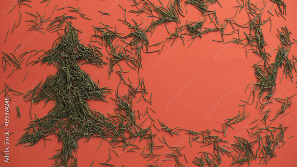conifer branches are laid out in the form of a Christmas tree on a red background conifer branches are laid out in the form of a Christmas tree on a red background