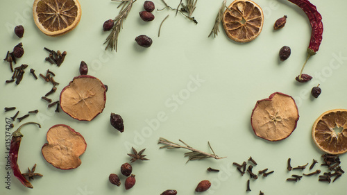 dry fruits and spices lie on a green background