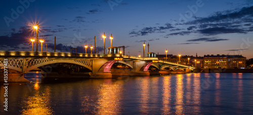 Night cityscape with river and bridge in Saint-Petersburg.
