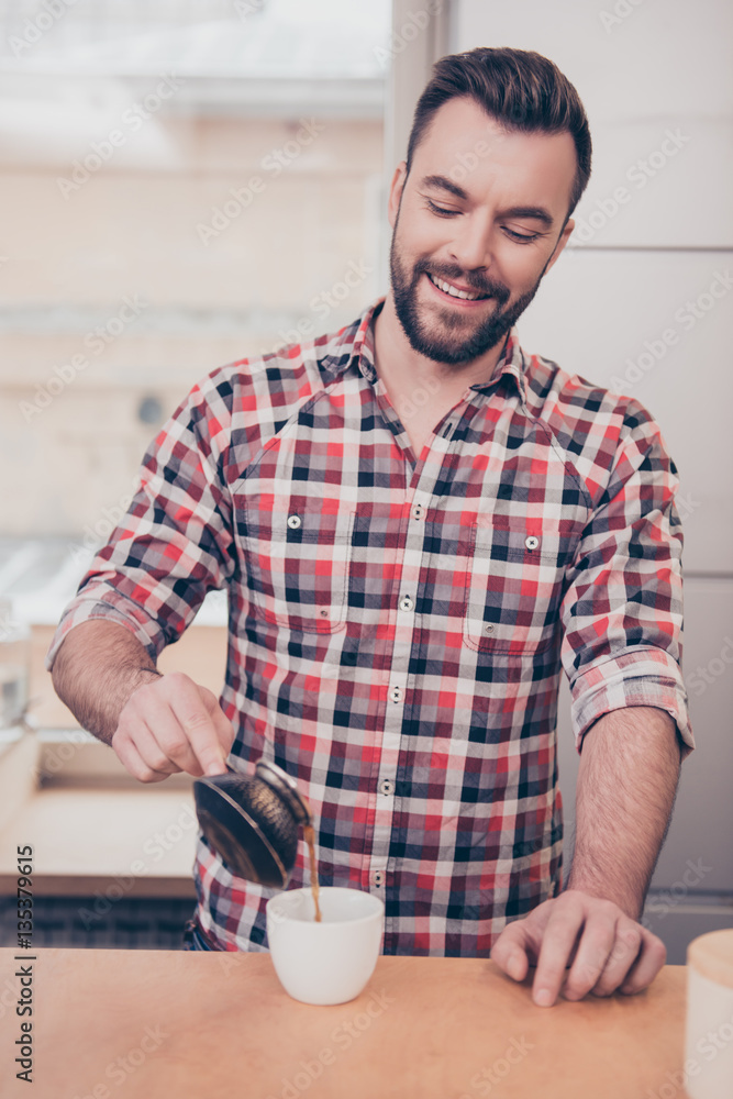 Portrait of handsome smiling barista pouring coffee in cup Portrait of handsome smiling barista pouring coffee in cup