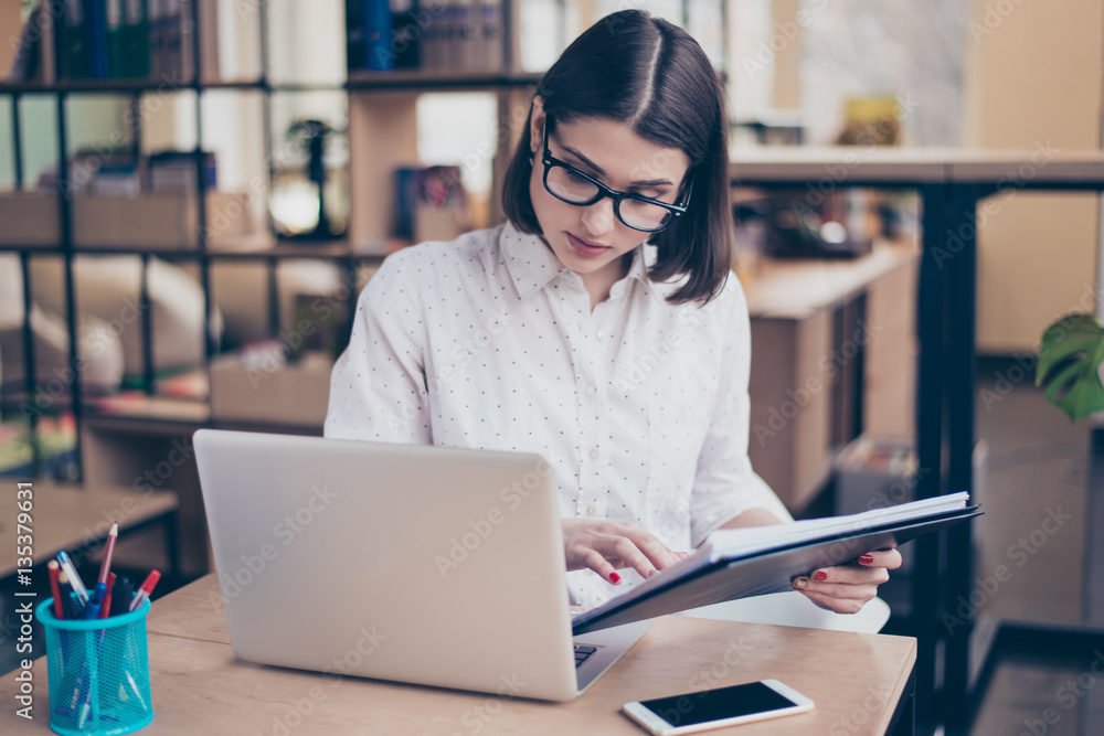 Concentrated smart young businesswoman using her computer in of Concentrated smart young businesswoman using her computer in of
