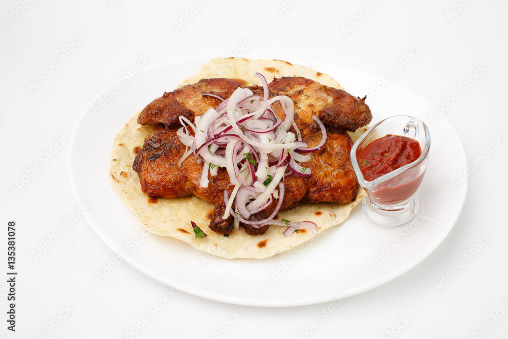 Fried chicken on pita bread with red sauce on a white background Fried chicken on pita bread with red sauce on a white background