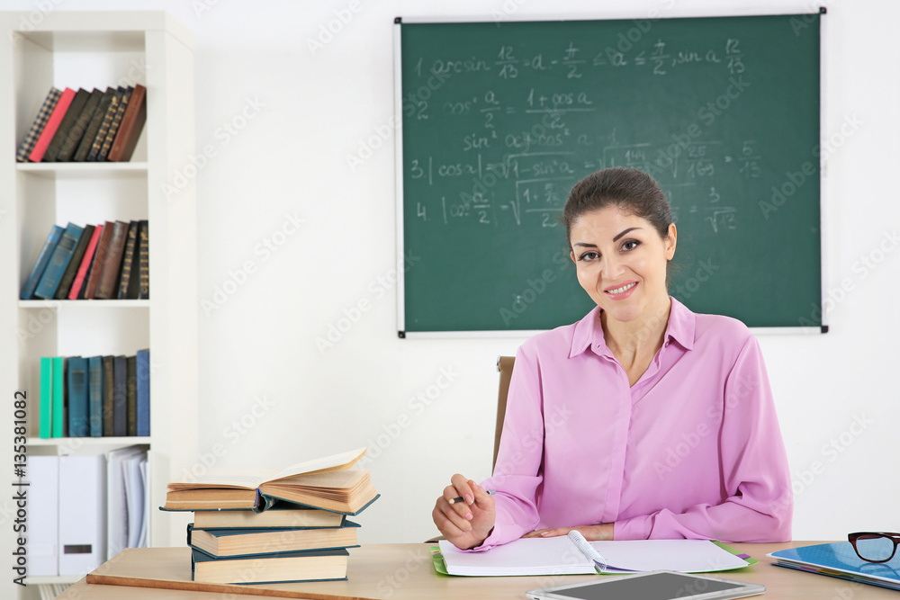 Young beautiful teacher in classroom Young beautiful teacher in classroom