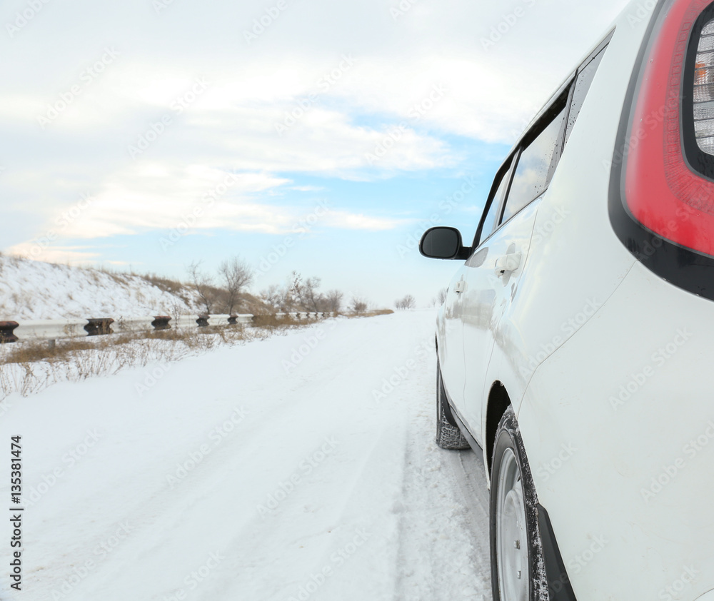 White car driving on snowy winter road White car driving on snowy winter road