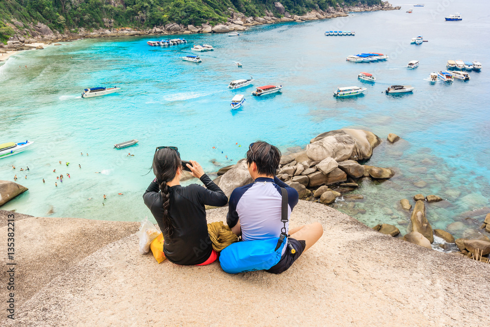 Happy Loving couple on a cliff view tropical beautiful crystal clear sea at tropical island, Similan Islands National Park, Phang Nga, Thailand Happy Loving couple on a cliff view tropical beautiful crystal clear sea at tropical island, Similan Islands National Park, Phang Nga, Thailand
