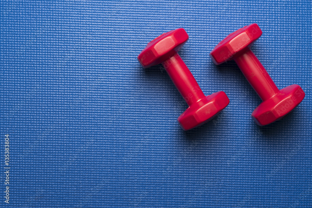 dumbbell and yoga mat on wood table dumbbell and yoga mat on wood table