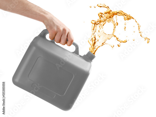Fotografie Man pouring oil out of plastic canister on white background