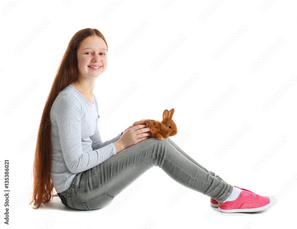 Fototapeta premium Cute girl holding small rabbit on white background