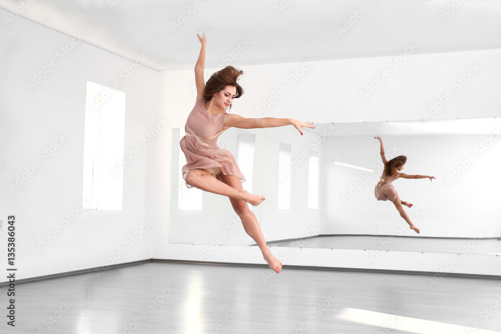 Fototapeta premium Beautiful young woman dancing in studio
