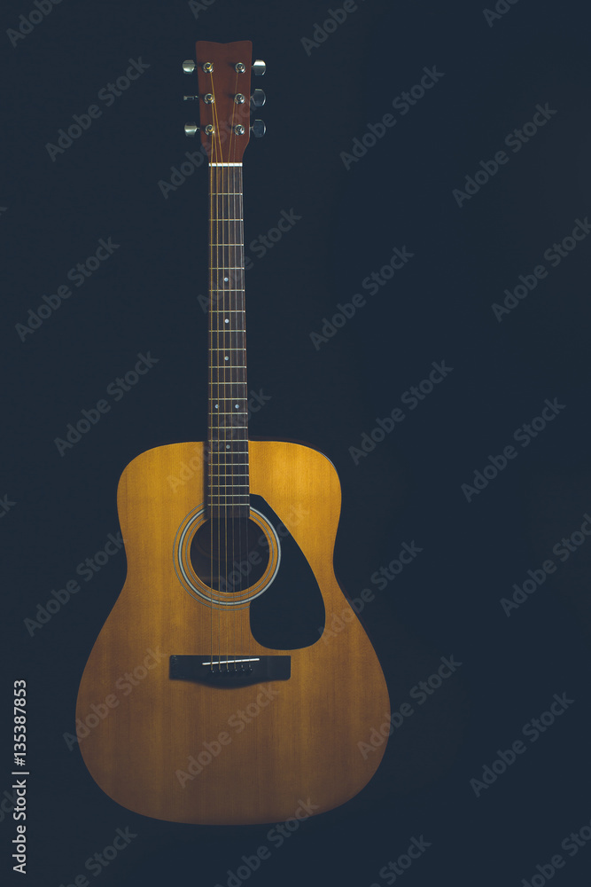 Acoustic guitar on a black background with copy space Acoustic guitar on a black background with copy space
