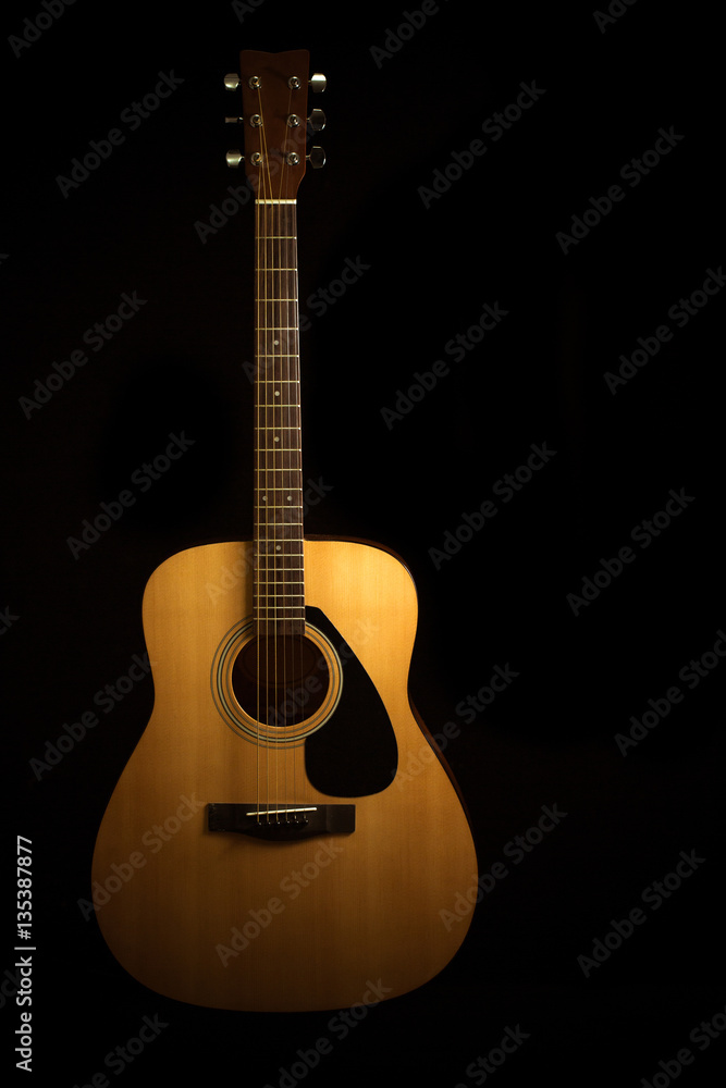Acoustic guitar on a black background with copy space Acoustic guitar on a black background with copy space