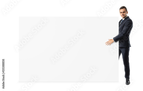 Businessman on white background is holding a shoulder-height blank display board