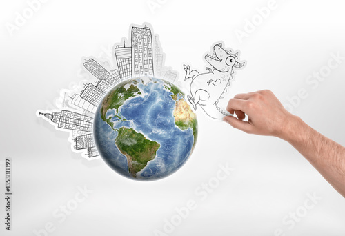 Man s hand holding cartoon funny monster going to attack city put around the globe on