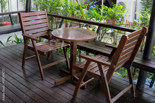 brown wood table and chairs set on terrace.