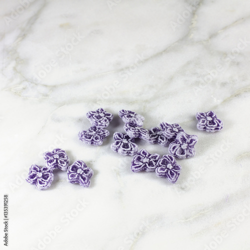 Fototapeta Naklejka Na Ścianę i Meble -  Violet candies, typical Madrid sweets, on white marble