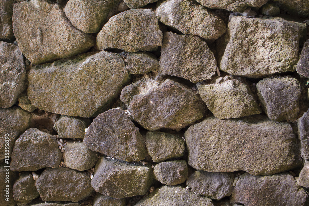 Stone wall background or wallpaper. Irregular grey stone bricks design Stone wall background or wallpaper. Irregular grey stone bricks design