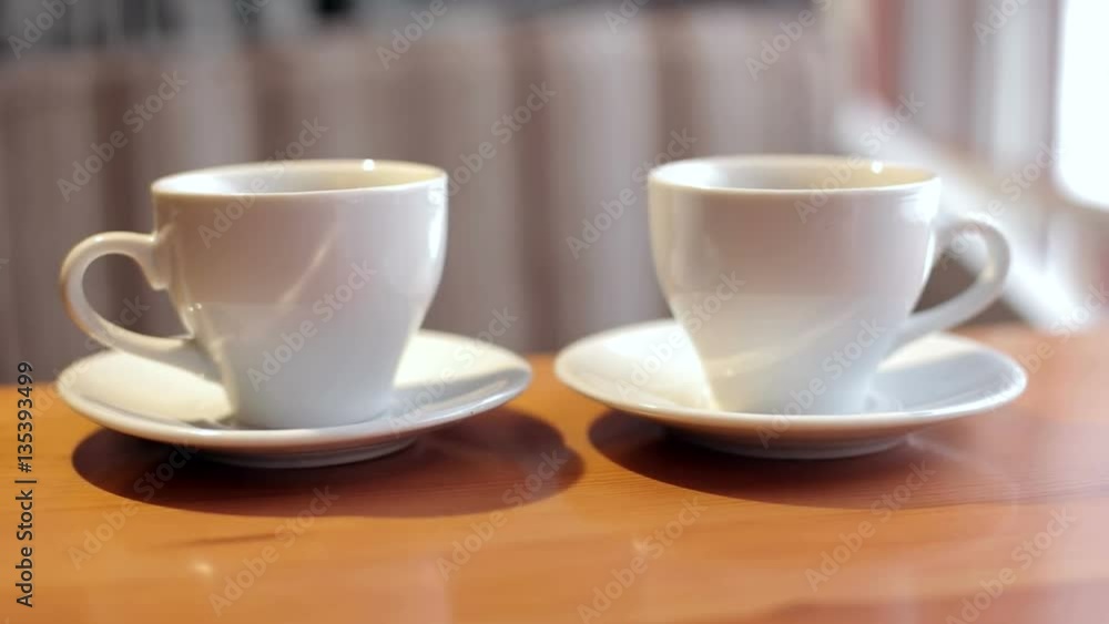 Two white cups of coffee a close-up. Two white cups of coffee a close-up.