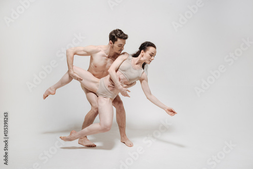 Muscular young actors performing in the white colored studio