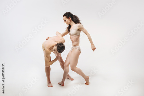 Confident ballet dancers performing in the white colored studio