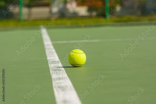 Green tennis balls are in a tennis court. © dsom