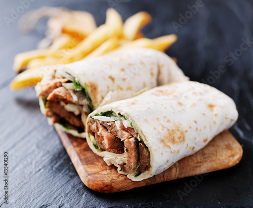 greek gyro wrap cut in half and served with fries
