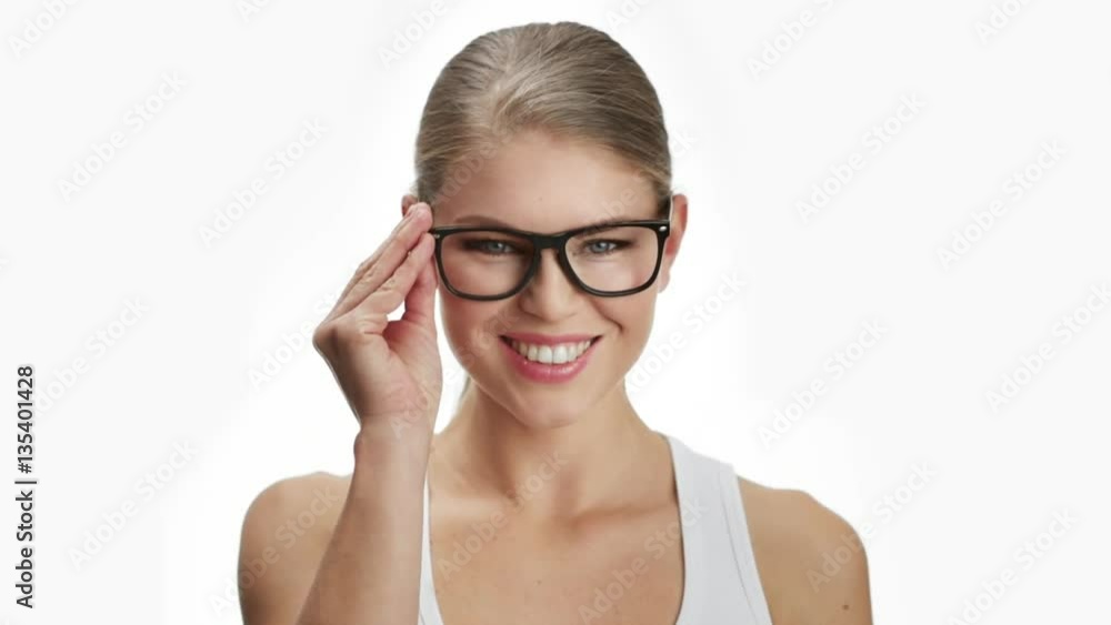 Young attractive woman putting on stylish spectacles. Concept of eyesight examination and optics. Young attractive woman putting on stylish spectacles. Concept of eyesight examination and optics.
