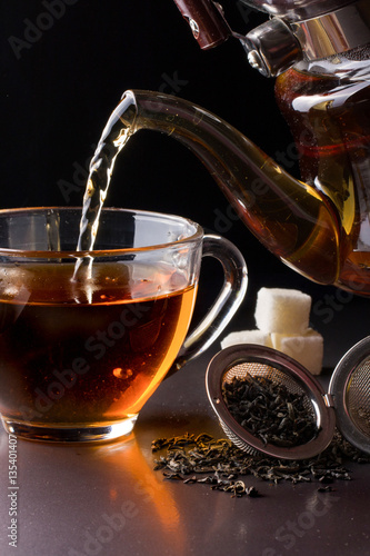 cup of tea with teapot on dark background © kolesnikovserg