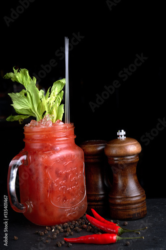 Bloody Mary or Ceasar with celery in mason jar rimmed black pepper
