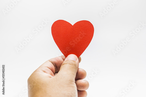 A man holding a red heart shape in his hands on white background