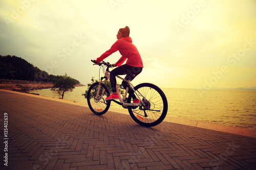 one young woman riding bike on seaside
