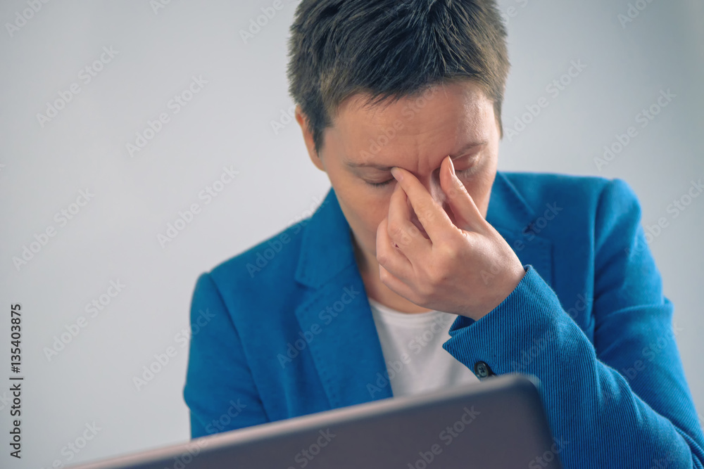 Exhausted businesswoman working overtime on office laptop comput Exhausted businesswoman working overtime on office laptop comput