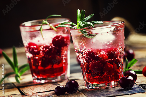 Cranberry beverage with ice and berries  vintage wooden backgrou