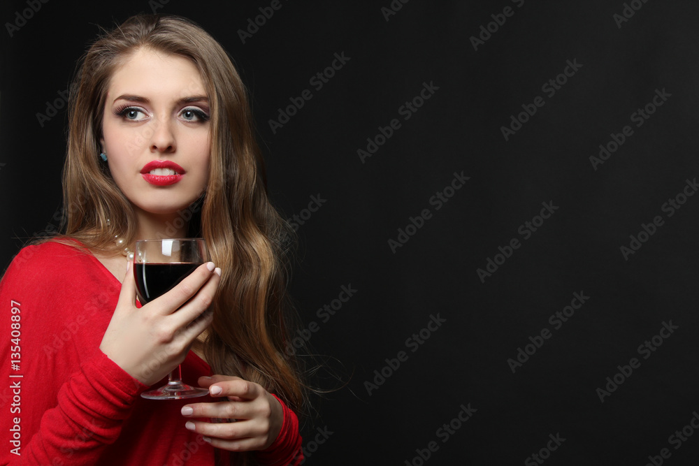 Sexy girl posing with a glass of wine in her hand on a dark background. Sexy girl posing with a glass of wine in her hand on a dark background.