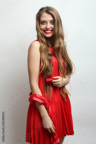 Beautiful girl model posing in stylish red dress.