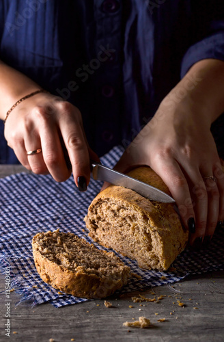 Female hands slicing homemade bread