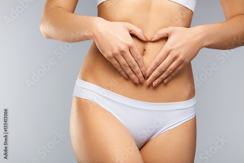 Health. Сloseup Beautiful Body With Heart Shaped Hands On Belly