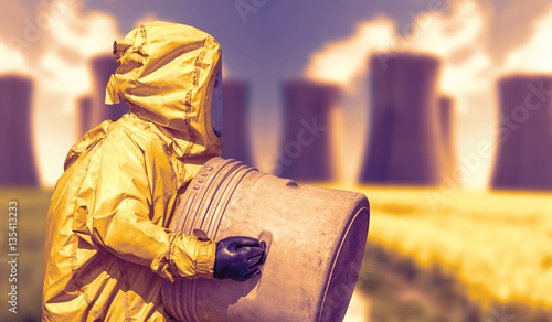 Abstract view of smoking coal power plant and men in protective hazmat suit 