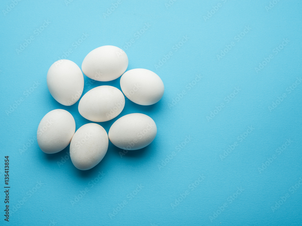 White chicken eggs on the blue background. White chicken eggs on the blue background.