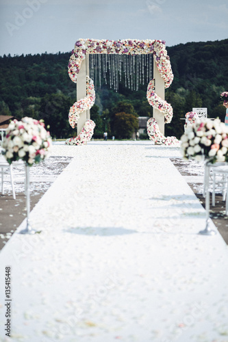 Two bouquets of roses stand on both sides of the path to wedding