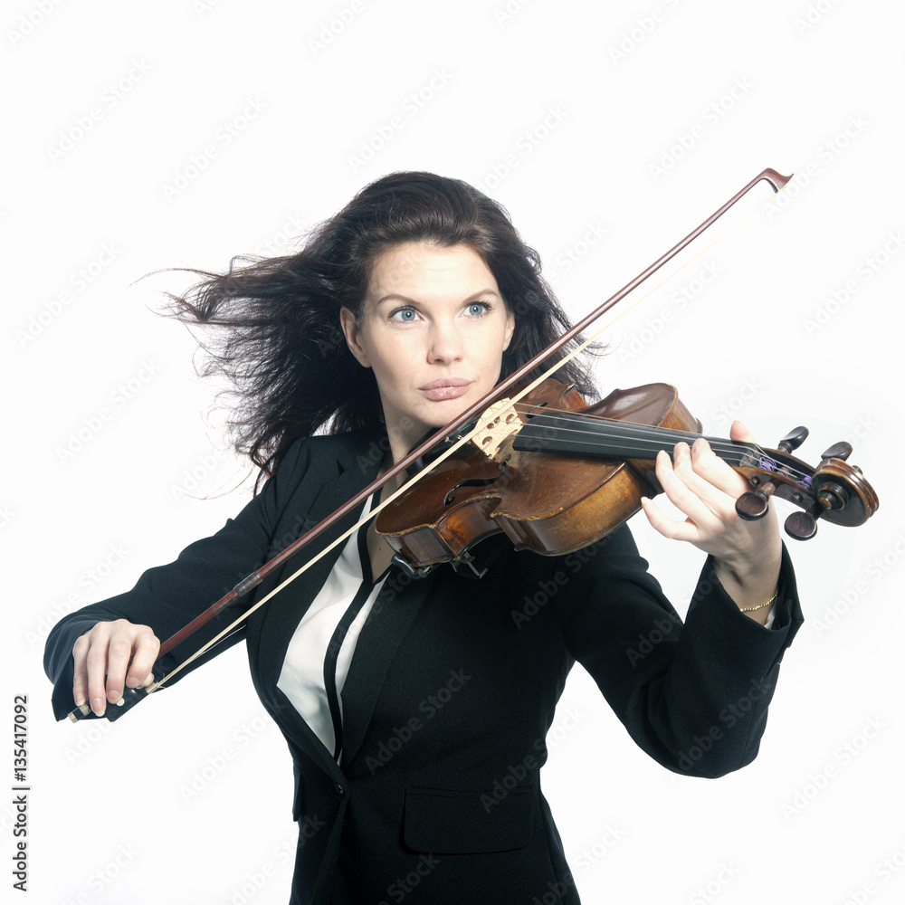 classical brunette beauty in suit plays the violin in studio