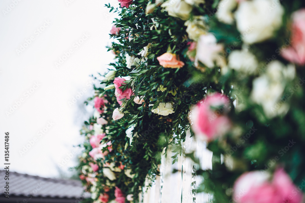 Close-up of roses put in dark garland on wedding altar