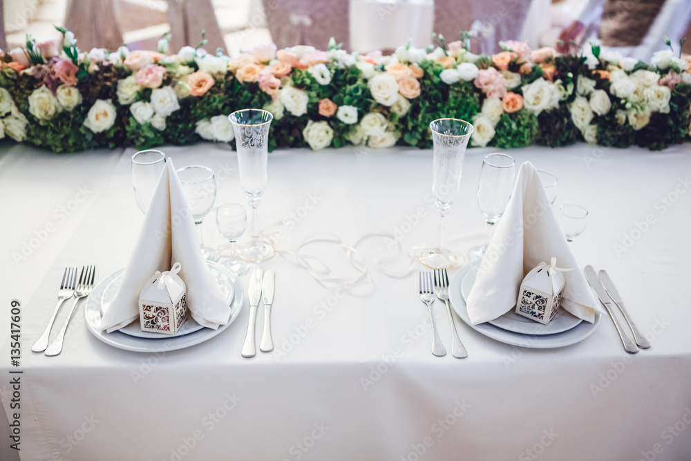 Fototapeta premium Look from above at white serviettes on dinner plates and green g
