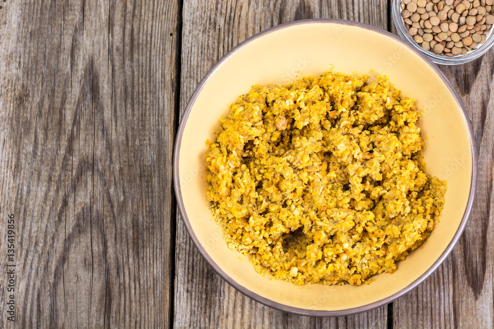 Side dish of lentils with vegetables, butter in bowl on wooden b Side dish of lentils with vegetables, butter in bowl on wooden b