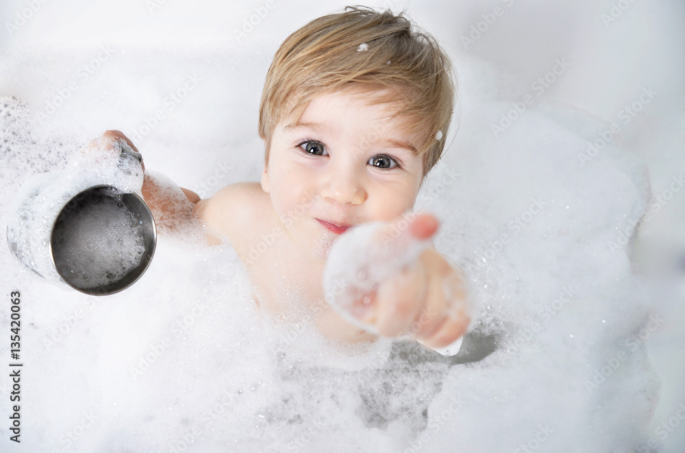small child takes a bath with foam - obrazy, fototapety, plakaty 