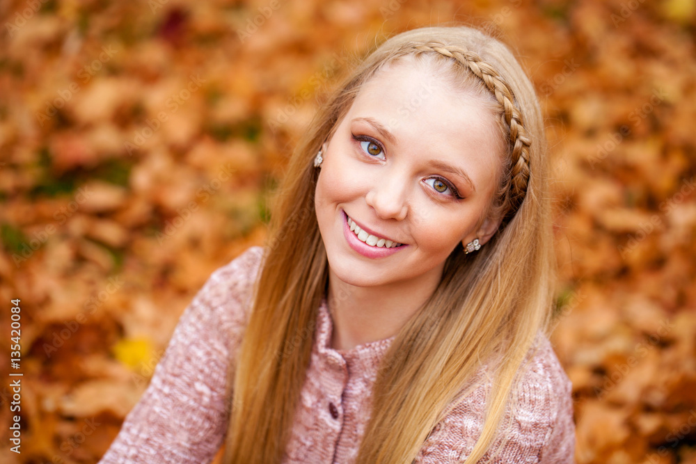 Close up portrait of young blonde beautiful woman in autumn park