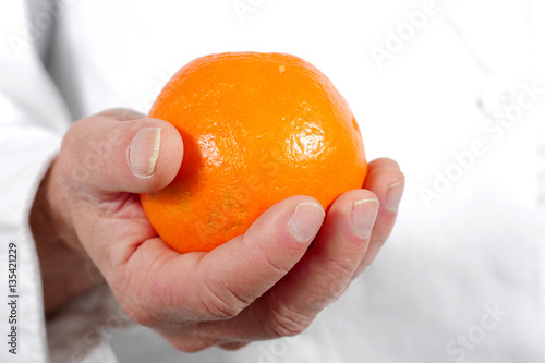close up of hand man holding orange